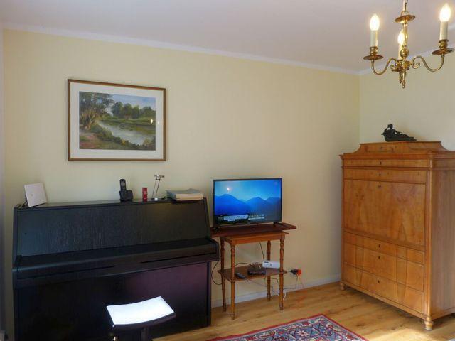 Wohnzimmer mit Klavier und TV