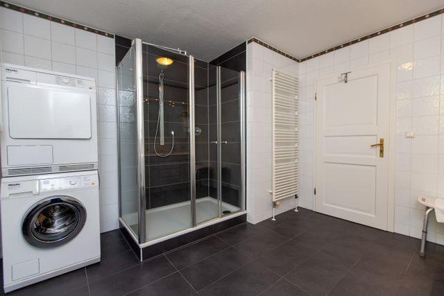 Badezimmer mit ebenerdiger Dusche und Waschmaschine