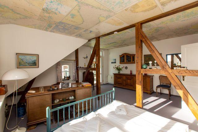 Schlafzimmer mit Blick auf Schreibtisch und Zugang zur Dachterrasse