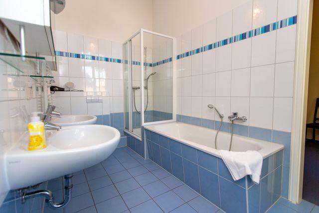 Badezimmer mit Badewanne und Dusche