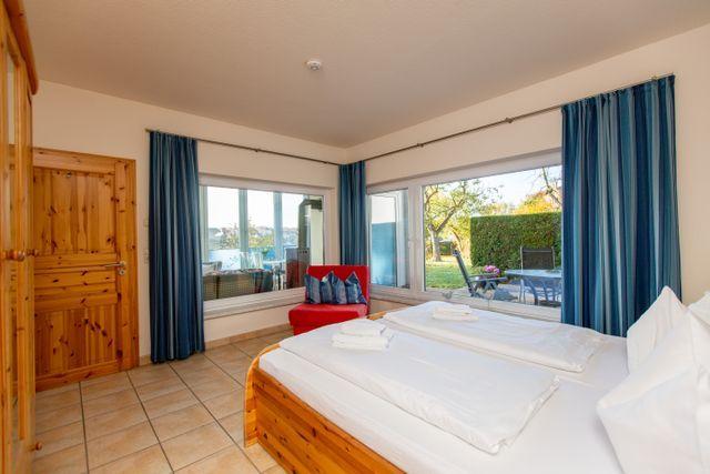 Schlafzimmer mit Ausblick auf den See und den Garten